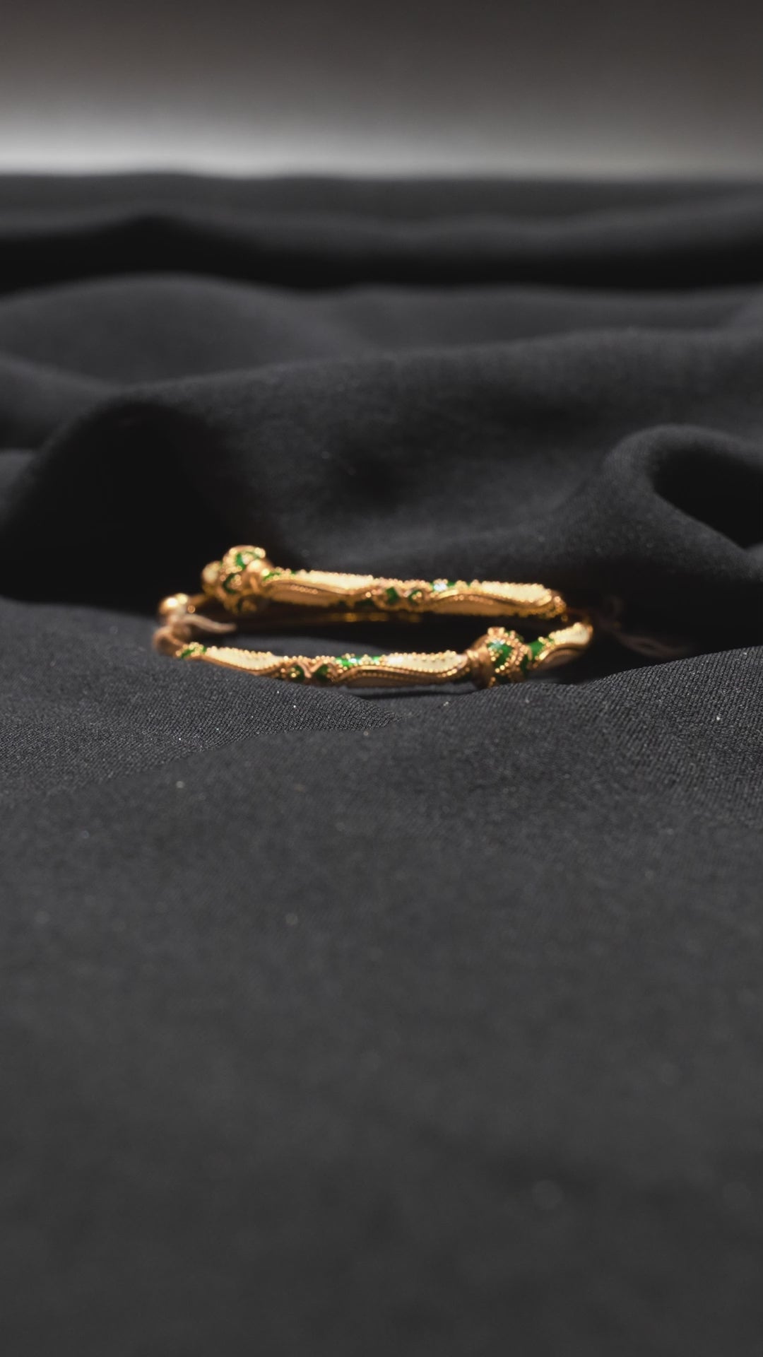 Video showcasing handcrafted 22K Gold Antique Bangles with intricate green and white designs, highlighting their timeless elegance and fine craftsmanship.